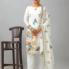 Woman wearing a white embroidered kameez set with a matching dupatta and fully stitched bottom, featuring intricate multicolor detailing.