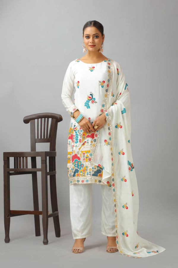 Woman wearing a white embroidered kameez set with a matching dupatta and fully stitched bottom, featuring intricate multicolor detailing.