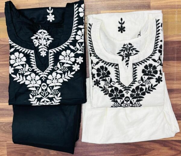 Two unstitched cotton Chikankari suits displayed side by side – one black with white floral embroidery, the other white with black floral embroidery, laid out on a wooden background.